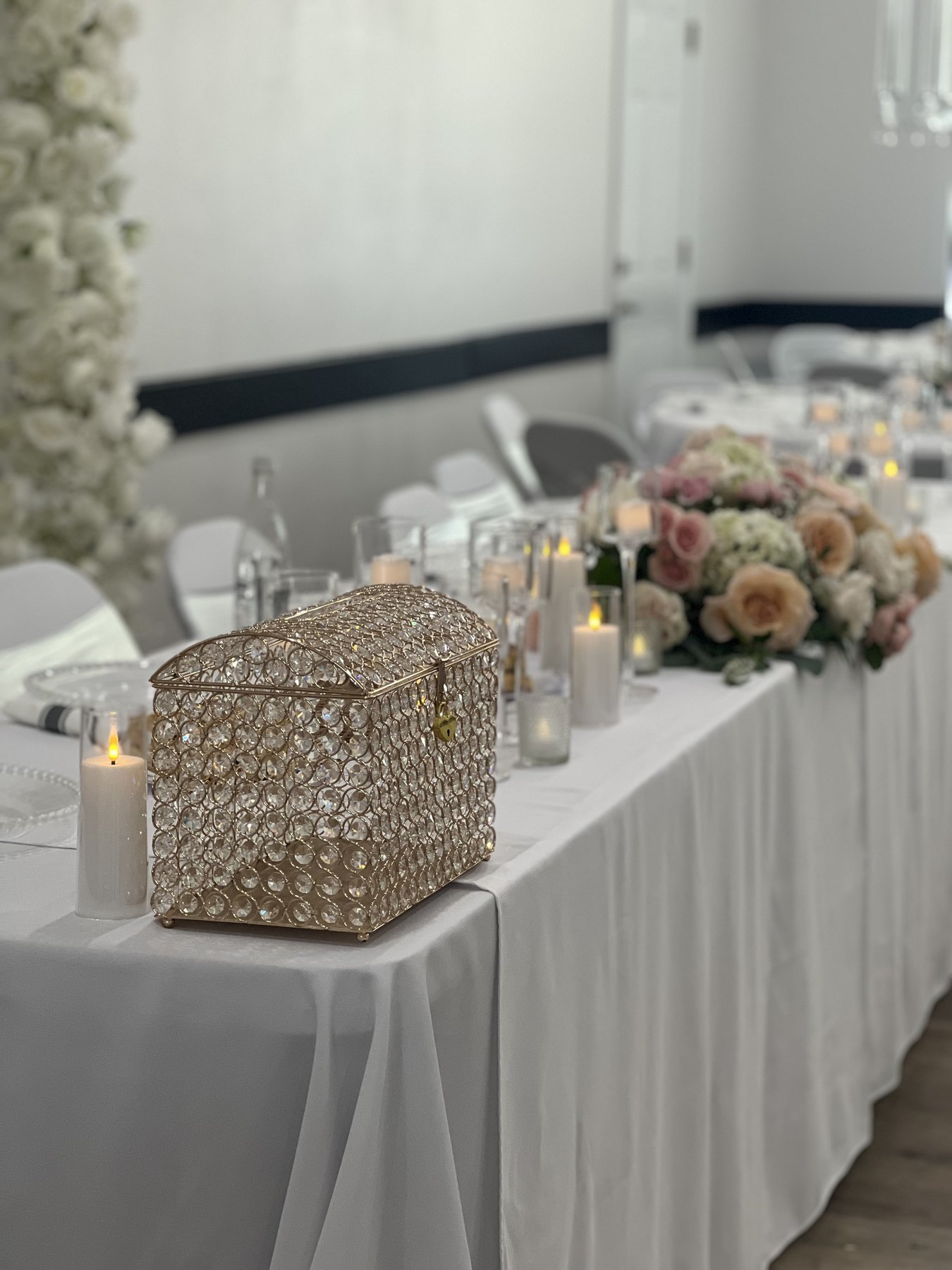 Gold favor boxes and floral accents on a white event table