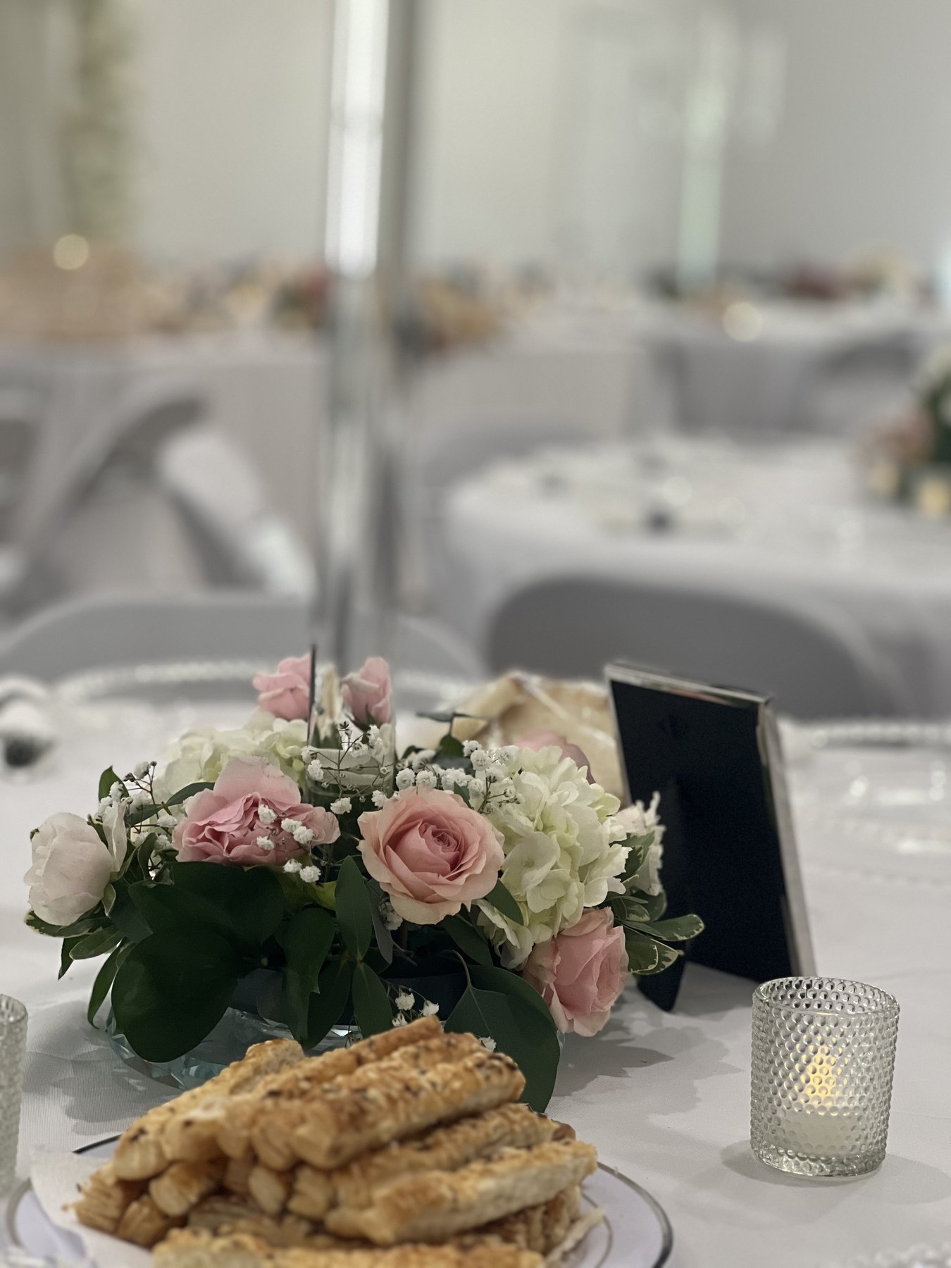 White event table with floral centerpiece and candles