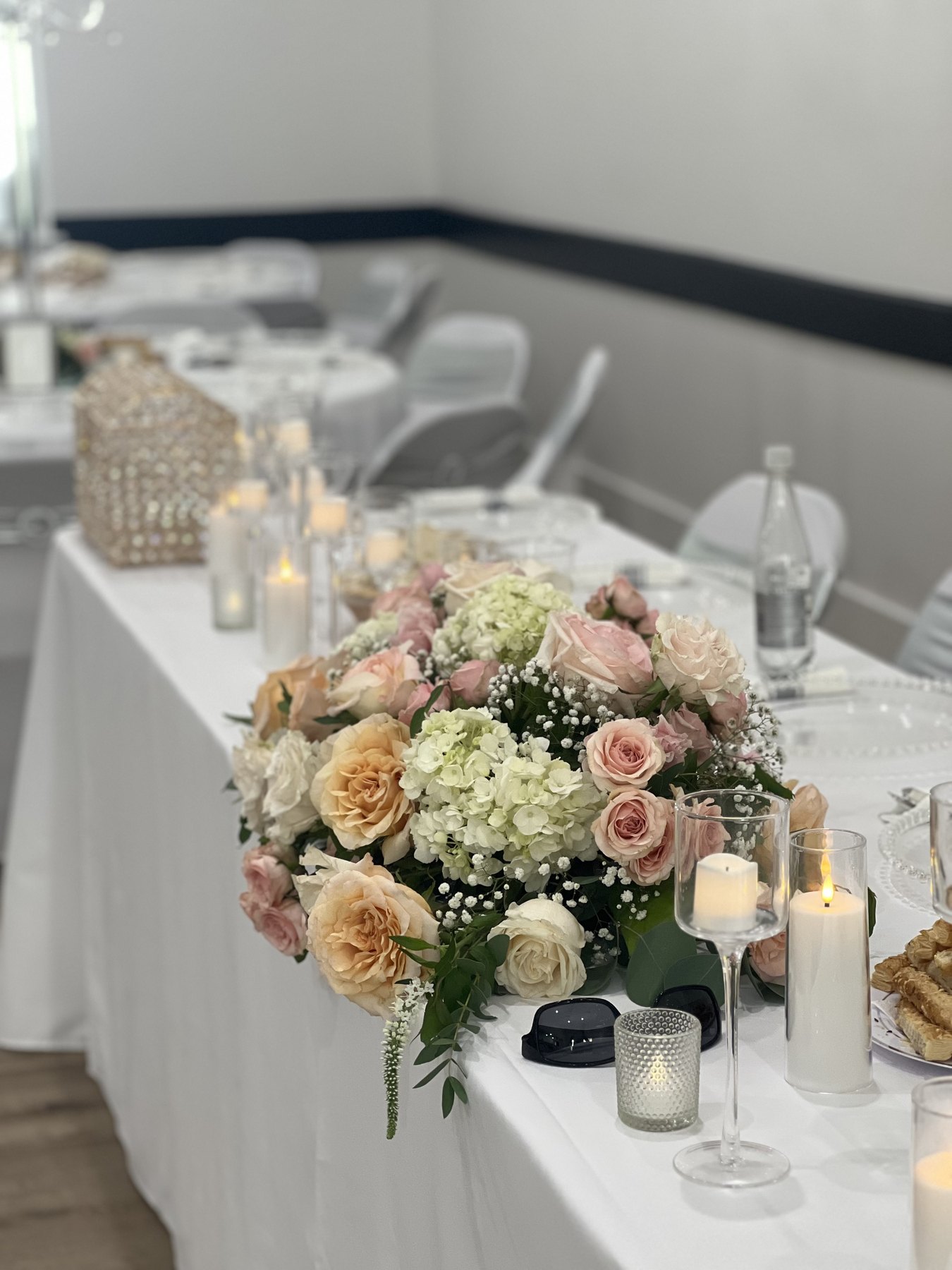 Blush and white floral centerpiece on a reception table