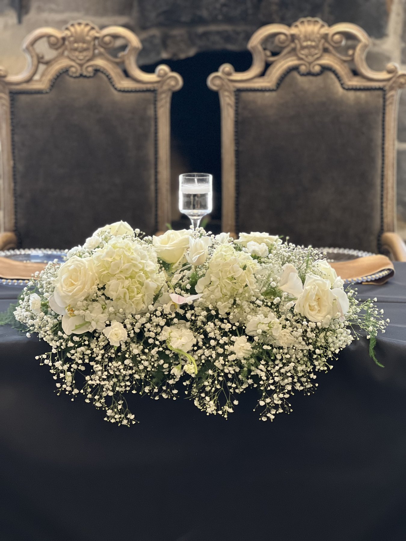 White and cream floral centerpiece on black table linen