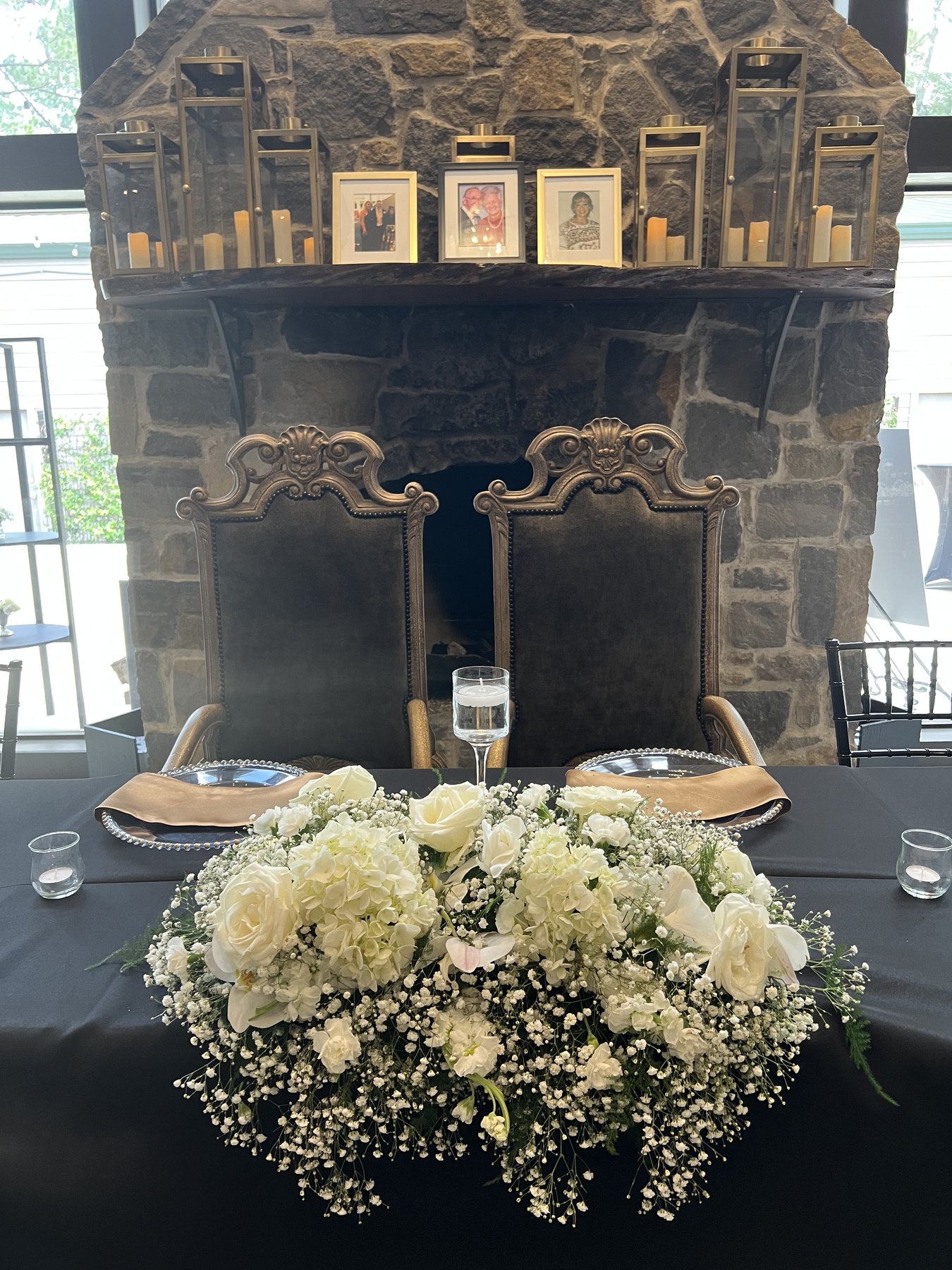 Formal head table with floral centerpiece and stone backdrop