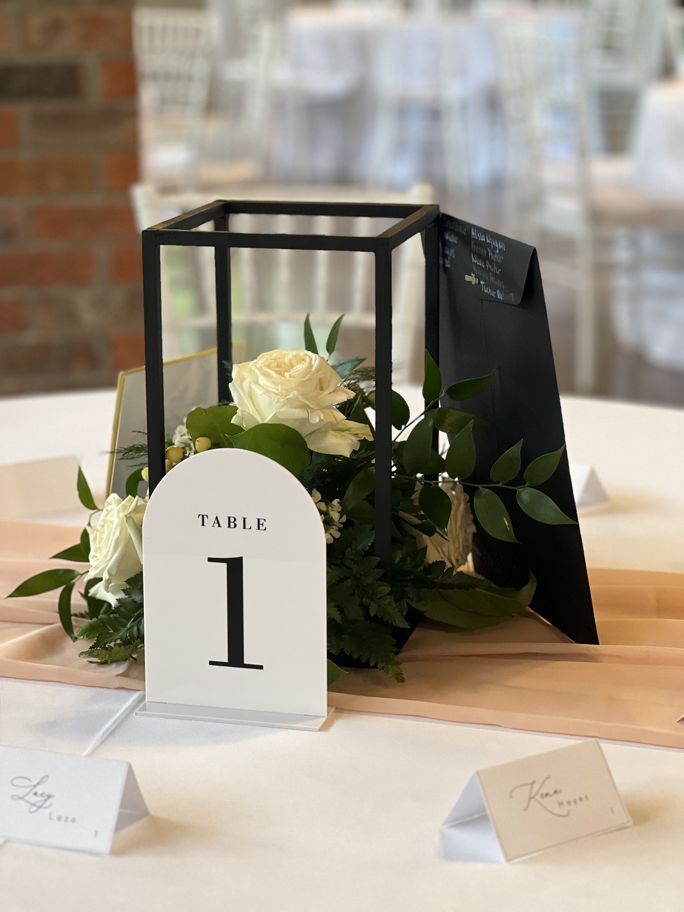 Black lantern centerpiece with white roses and greenery